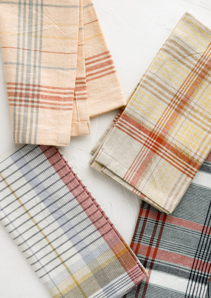1: A set of four napkins in plaid pattern and assorted colors.
