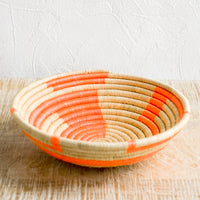 Natural / Neon Coral: A sweetgrass catchall bowl in tan and neon coral.