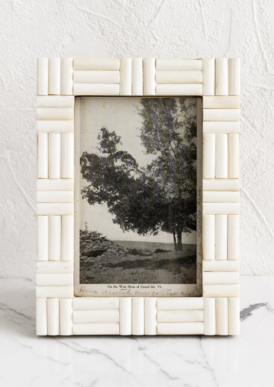 An ivory picture frame with alternating direction inlay.