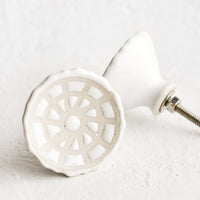 Kaleidoscope: White ceramic cabinet knobs with web-like relief pattern.