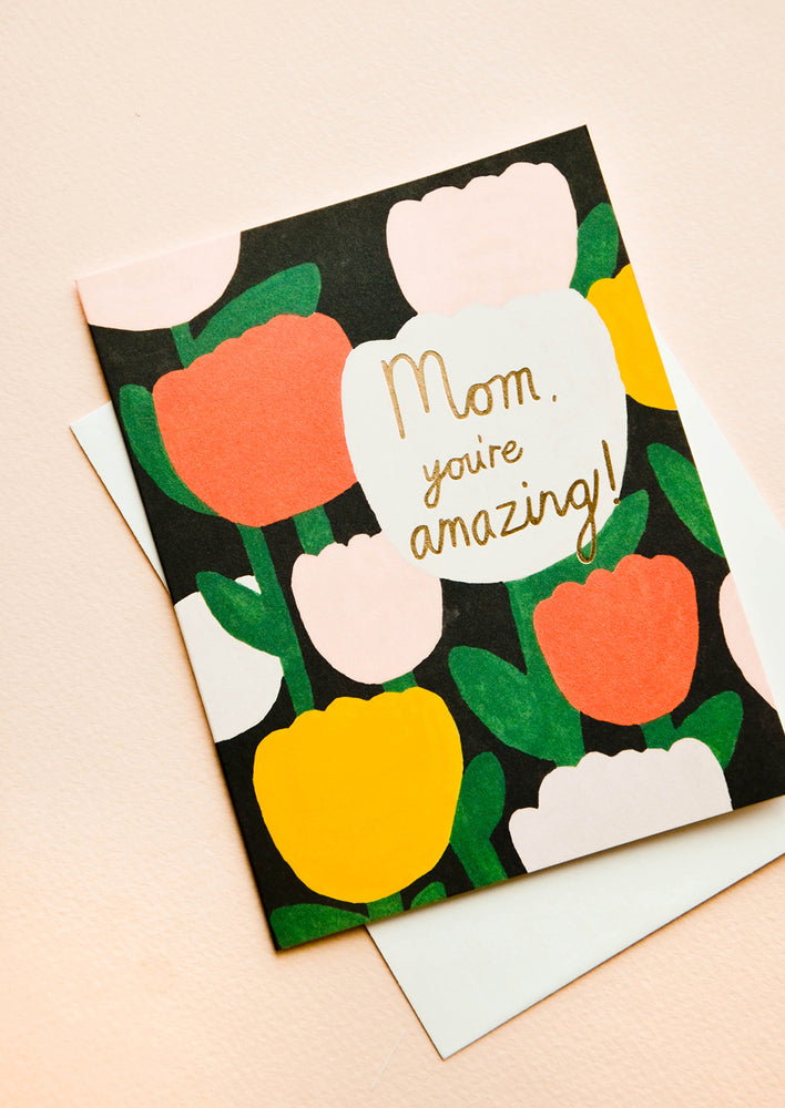 Greeting card with tulips printed on black background, text reads "Mom, you're amazing!"