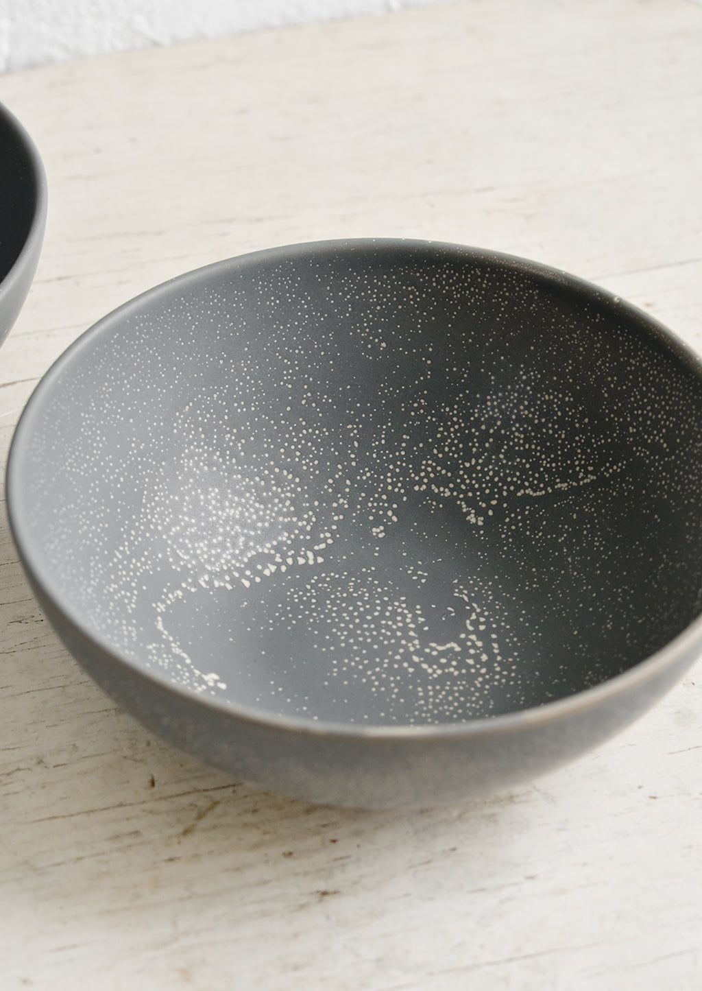 2: A dark grey ceramic bowl with light tan speckles.