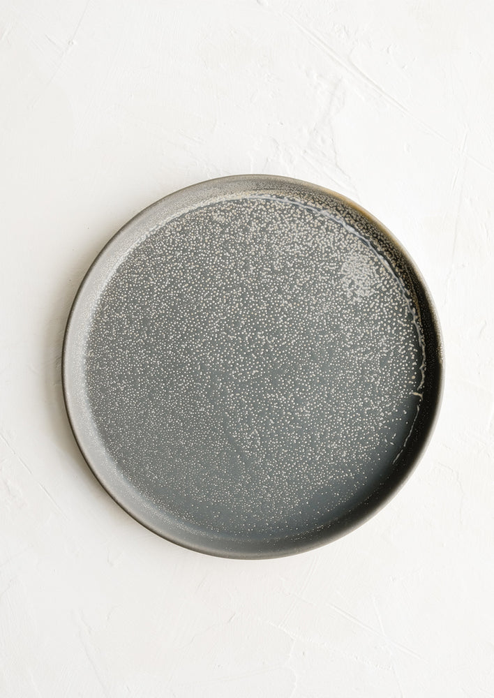 A round grey ceramic side plate with light speckles.