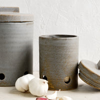 1: Ceramic kitchen storage jars in two sizes intended for onion and garlic storage.