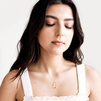 2: Model shot showing woman wearing necklace and white top.