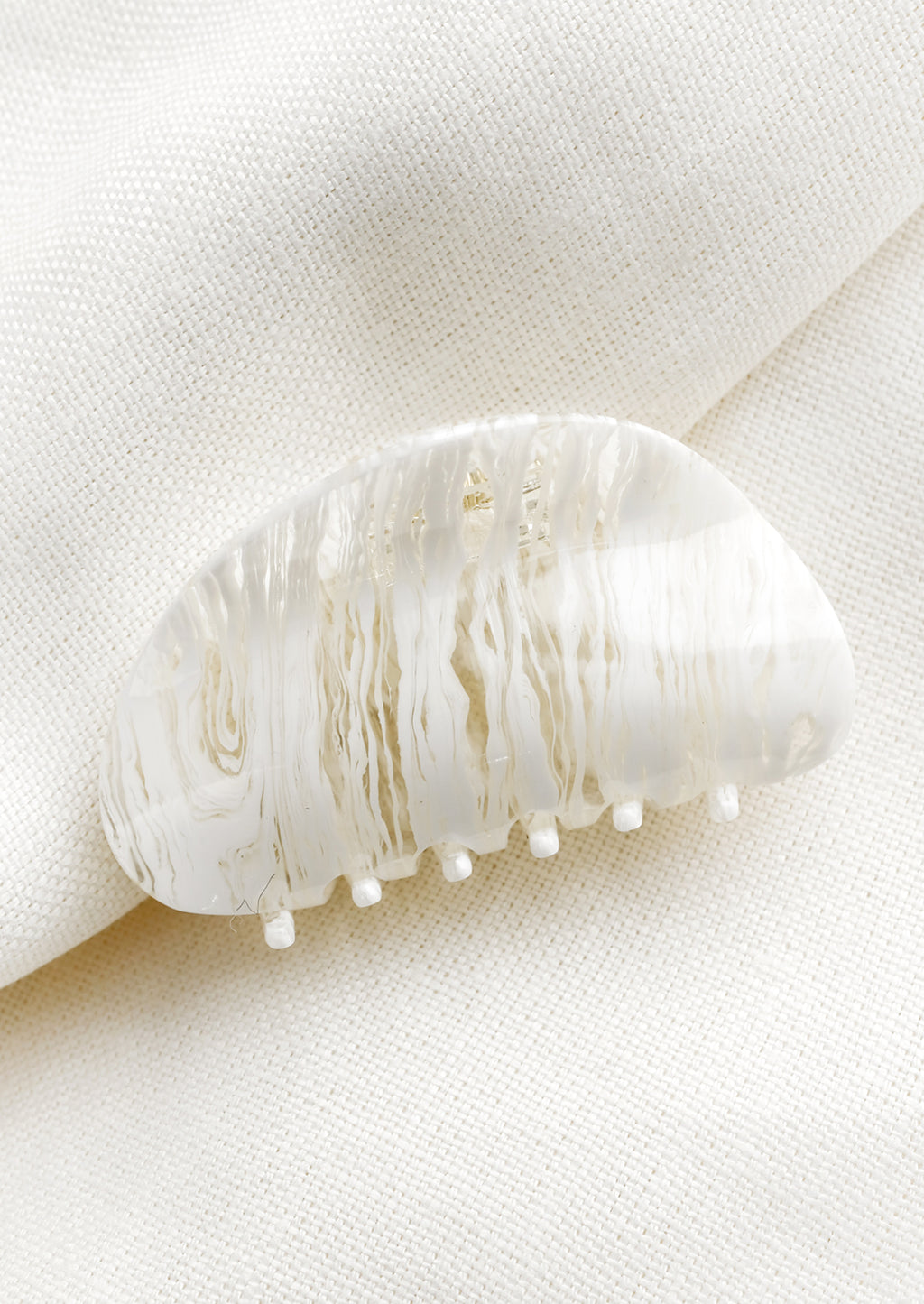 White: An asymmetric hair claw in white streak print.
