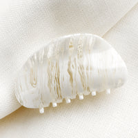 White: An asymmetric hair claw in white streak print.