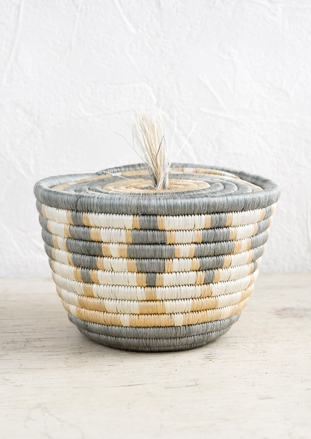 1: A small sweetgrass basket with flat lid and tassel detail.
