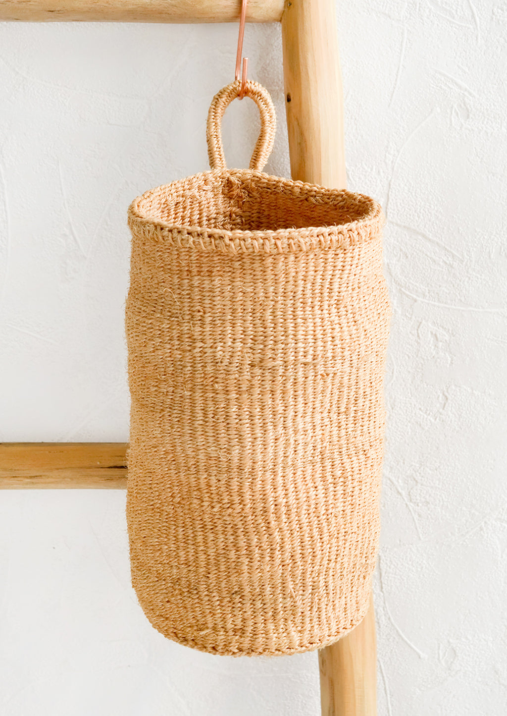Natural: An oblong cylindrical basket woven from sisal in natural color.