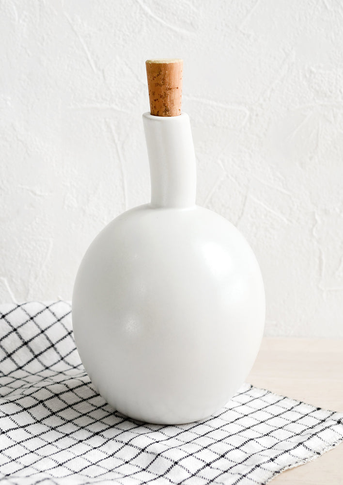 Satin White: A matte white ceramic cruet bottle with asymmetrical, bulbous silhouette.