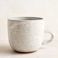 Aquinnah Speckle (Glossy): A short ceramic coffee mug in glossy natural glaze with brown speckles.