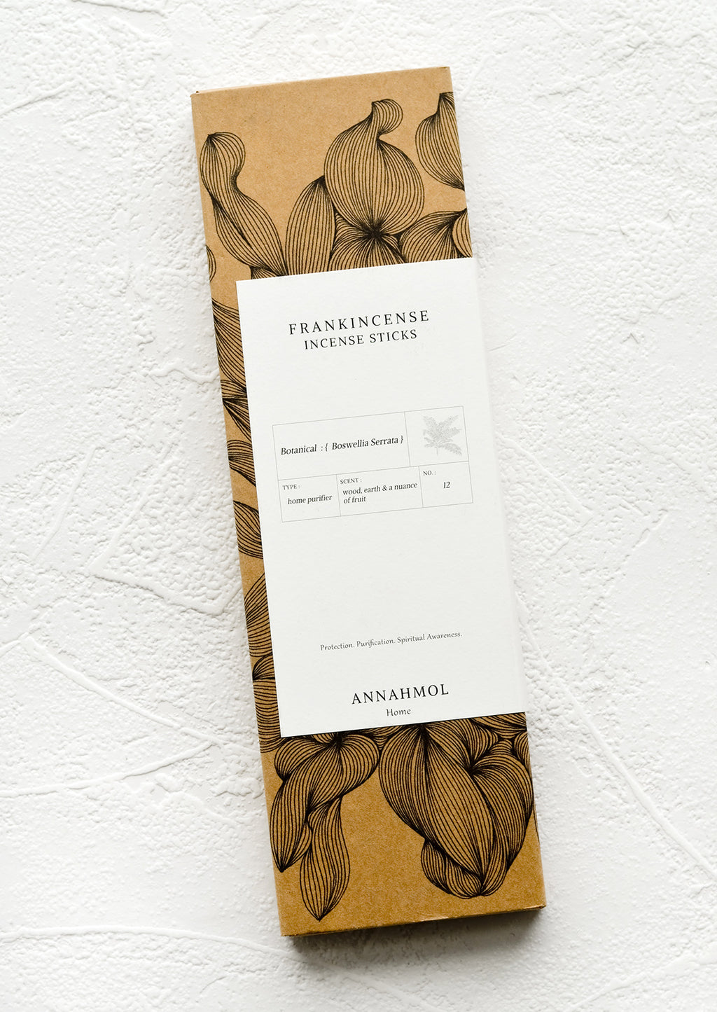 1: A kraft box with botanical print and white label.