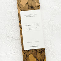 1: A kraft box with botanical print and white label.