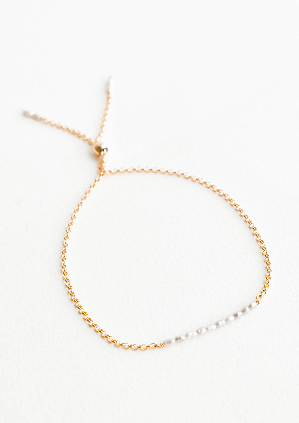 Freshwater Pearl: A delicate gold chain bracelet featuring a row of miniature freshwater pearls.