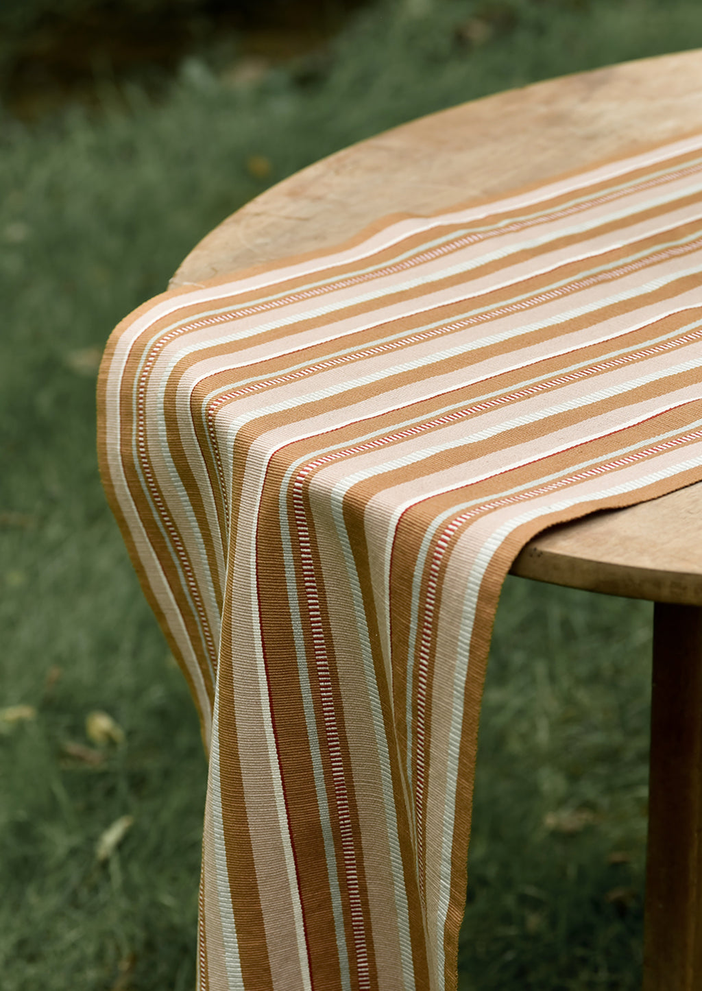 2: A tan striped table runner on a table.