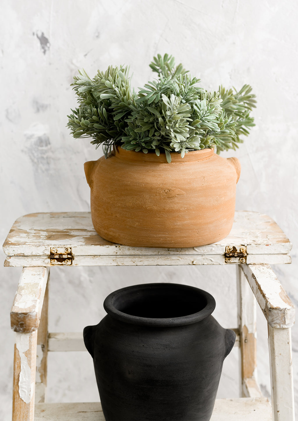 3: Weathered clay pots on a step stool.