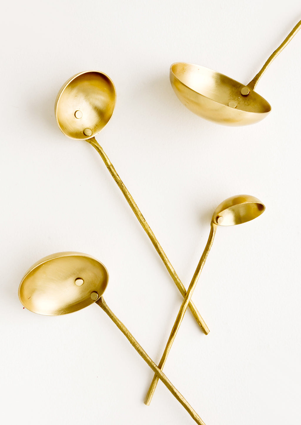 1: A set of four ladles in incremental sizes from extra small to large, crafted in solid brass with skinny handles