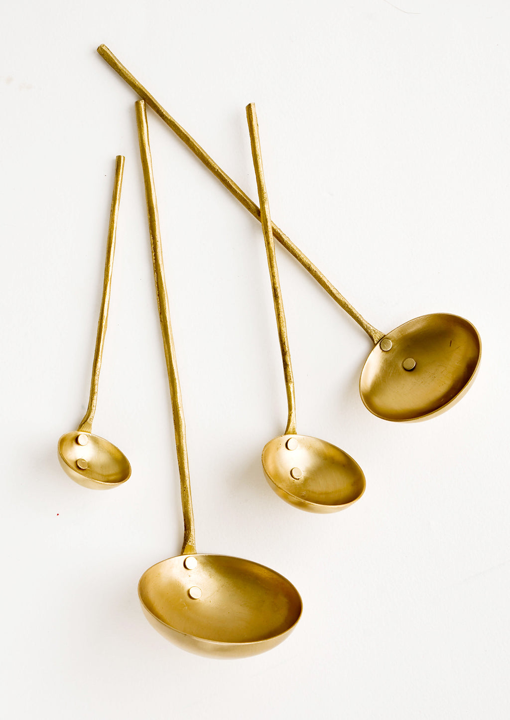 3: A set of four ladles in incremental sizes from extra small to large, crafted in solid brass with skinny, rough textured handles