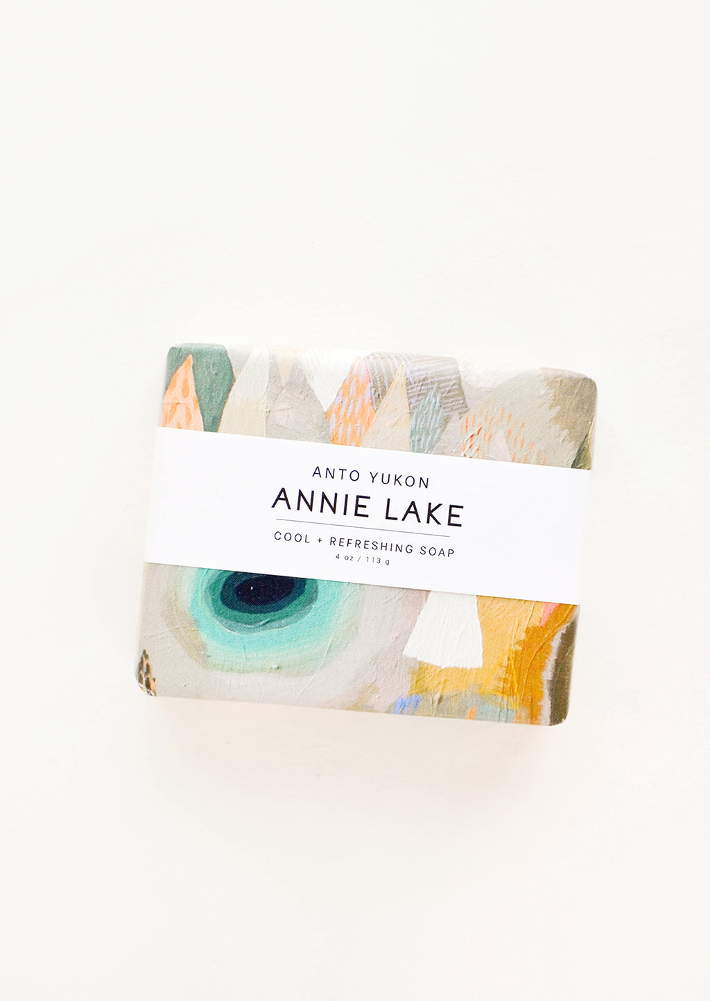 Annie Lake: A bar of soap in multicolored packaging with a white horizontal label.