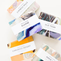 1: Five bars of soap in multicolored packaging with white labels.