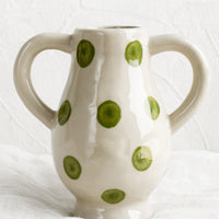 Green Dot: A ceramic vase in green dot pattern with side handle detail.