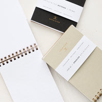 1: Small spiral bound notebooks with ruled pages.
