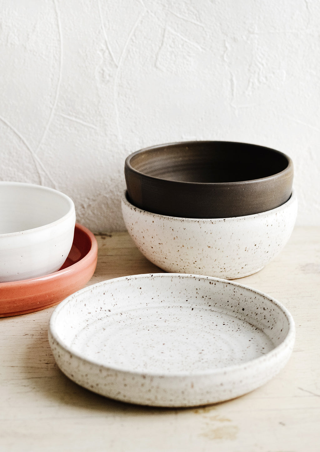Speckled White / Noodle Bowl: A collection of handmade ceramic bowls in various colors and sizes.