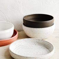 Speckled White / Noodle Bowl: A collection of handmade ceramic bowls in various colors and sizes.
