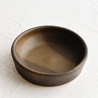 4: A small brown ceramic pinch bowl.