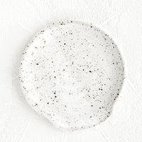 Speckled White: A round, handmade ceramic spoon rest in a speckled matte white glaze.