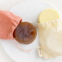 Conditioner Bar: Round solid shampoo & conditioner bars in muslin packaging.