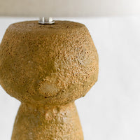 2: A textured brown stoneware table lamp.