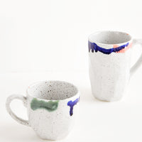 1: Two differently sized gray ceramic mugs with blue, green, and pink painted rims.