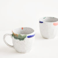 3: Two short gray ceramic mugs with blue, green, and pink painted rims.