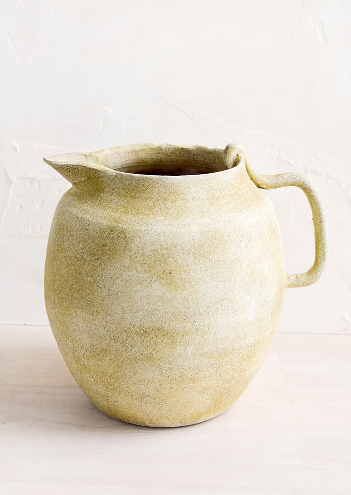 1: A ceramic pitcher meant to be used as a vase in distressed clay.