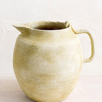 1: A ceramic pitcher meant to be used as a vase in distressed clay.