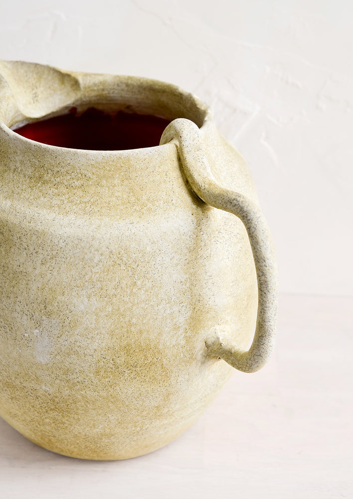 Curved handle on a ceramic pitcher.