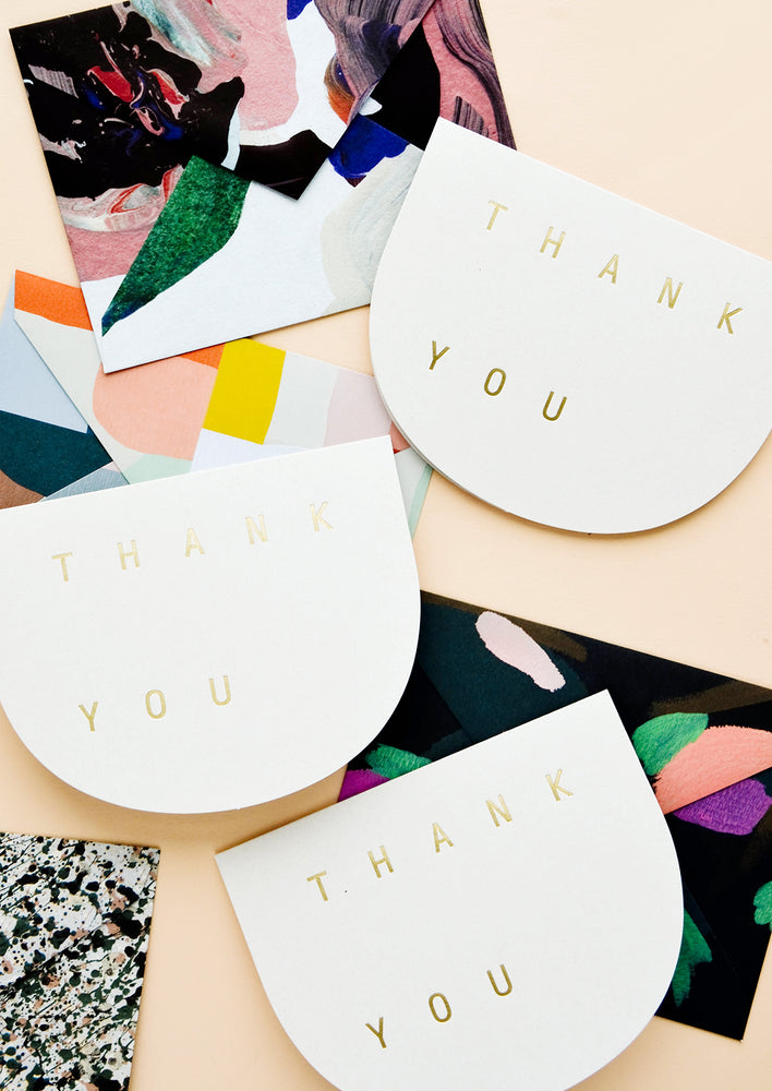 Thank you greeting cards in curved shape with golden letters, paired with abstract envelopes