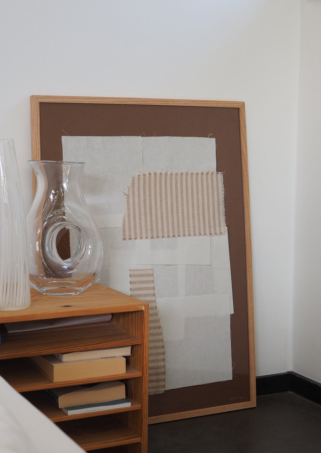 2: A brown art print with photographed textiles in ivory and tan stripes.
