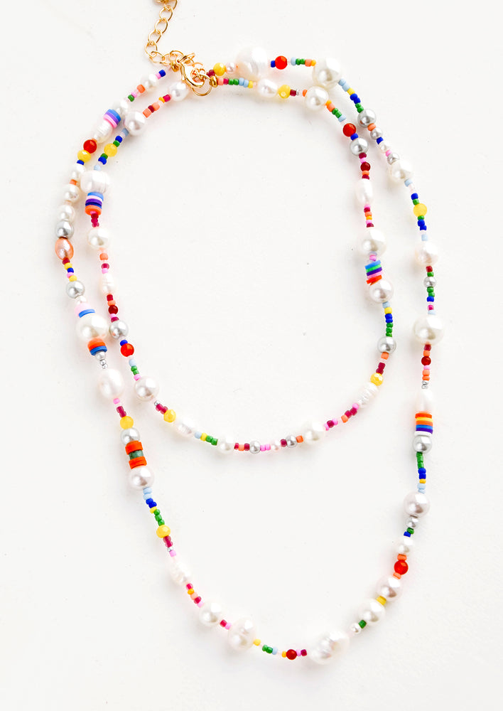 Long, layered beaded necklace in a mix of round pearl beads and rainbow colored beads