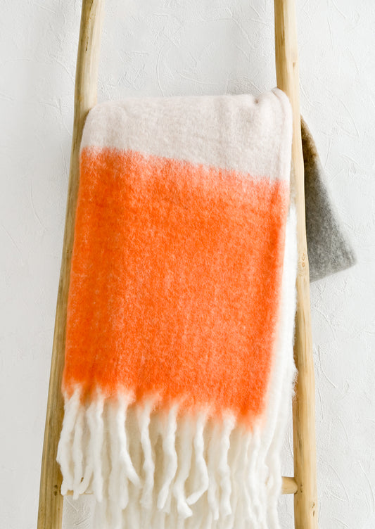 A throw blanket in orange multicolor.