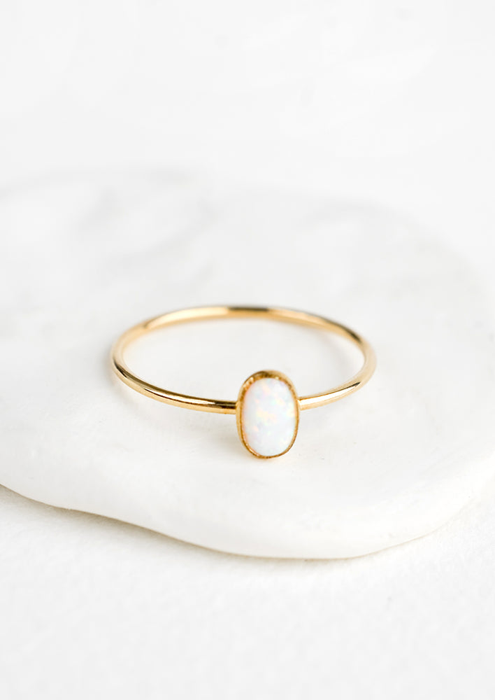 A thin gold ring with oval shaped opal bezel.