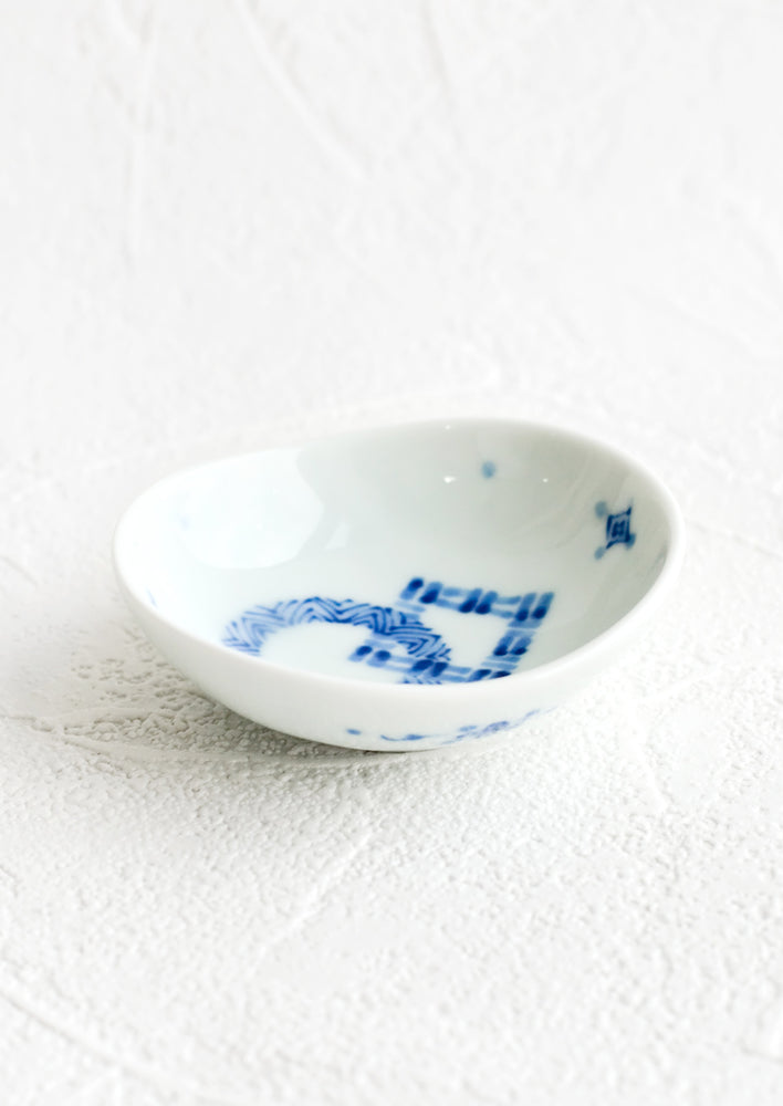 An oval-shaped blue and white ceramic sauce dish.