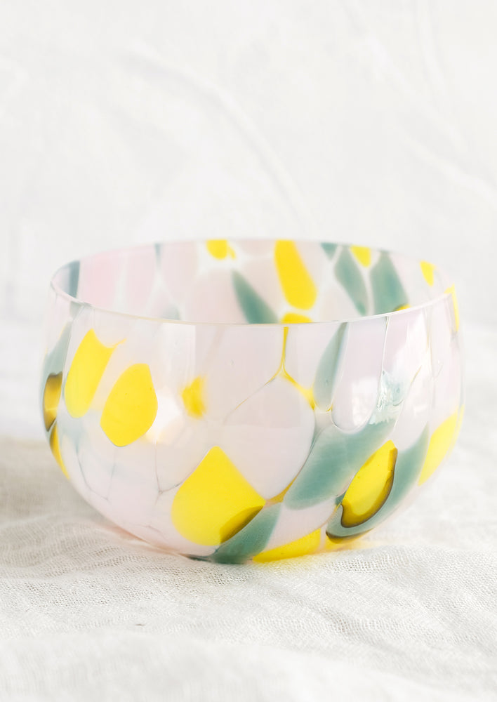 A speckled glass candy bowl in teal, pink and yellow.