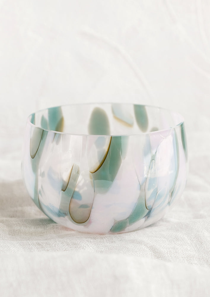 A speckled glass candy bowl in sea green and lilac.
