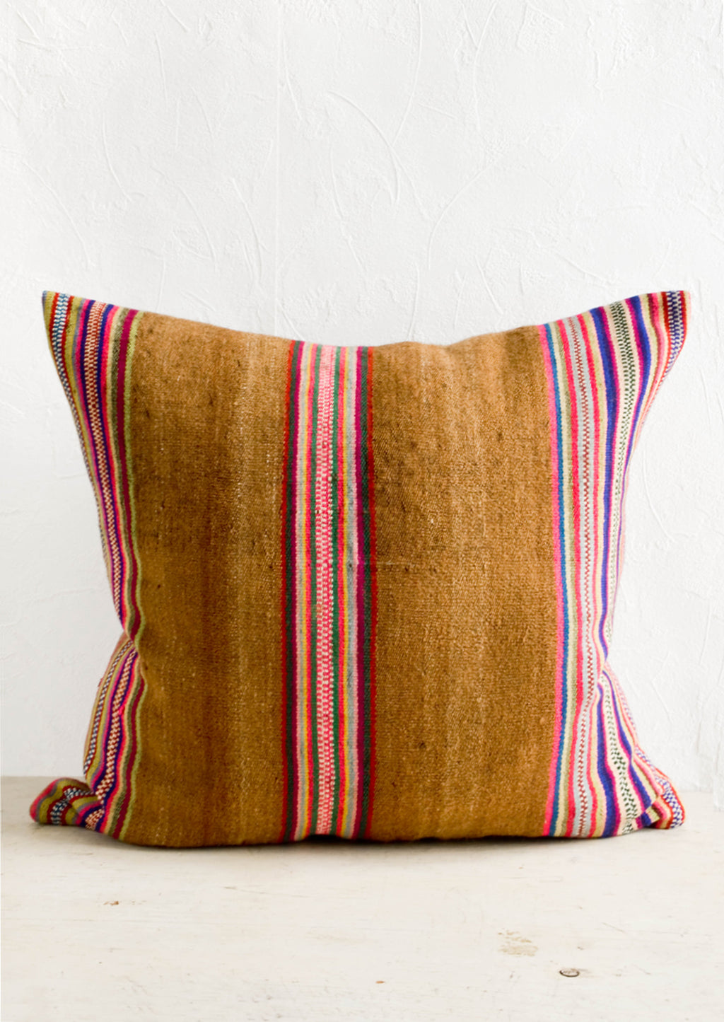 1: Square throw pillow in striped vintage wool fabric. Brown with colorful rainbow stripes.