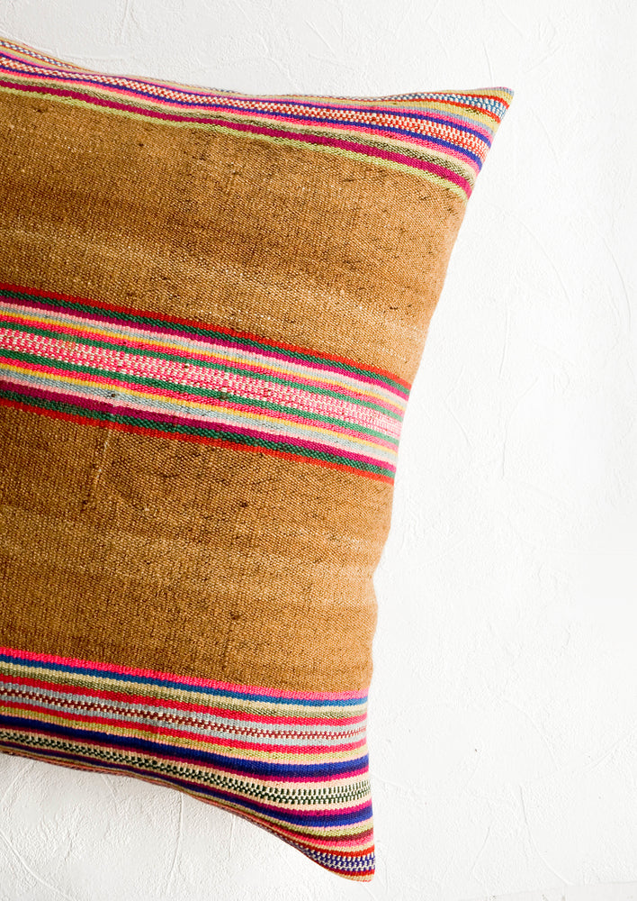 Square throw pillow in striped vintage wool fabric. Brown with colorful rainbow stripes.