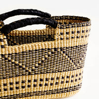 2: Black leather cutout handles on woven elephant grass tote
