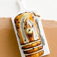 1: A decorative holiday ornament in shape of loaf of banana bread on platter.