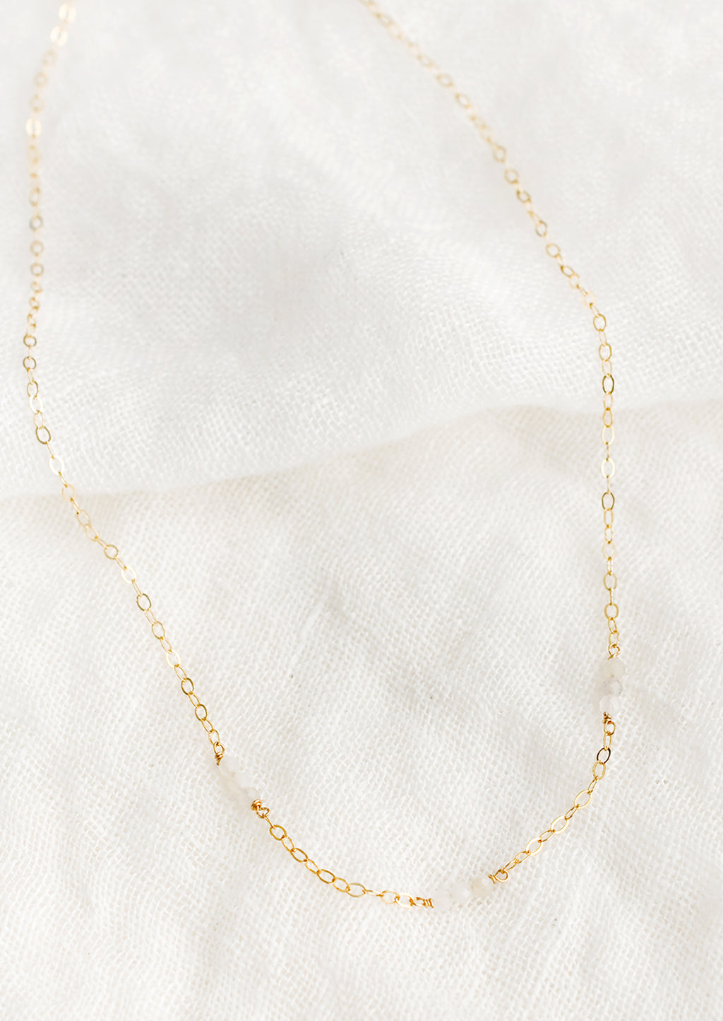 Moonstone: A delicate gold chain necklace with moonstone beaded stations.